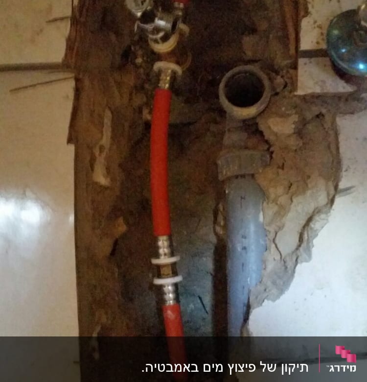 צינור אדום ושסתום בתוך קיר פתוח